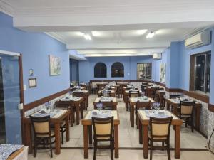 a restaurant with blue walls and wooden tables and chairs at Itajubá Hotel in Rio de Janeiro
