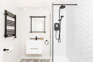 a white bathroom with a shower and a sink at Modern 2-Bedroom Apartments with Free Parking in Leamington Spa in Leamington Spa +141 photos