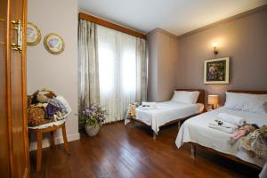 a hotel room with two beds and a window at Bozcaada Biz Otel in Bozcaada