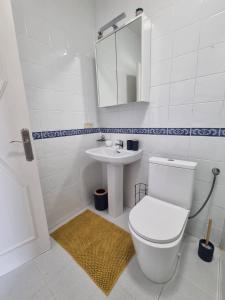 a white bathroom with a toilet and a sink at Los altos 1 in Los Altos