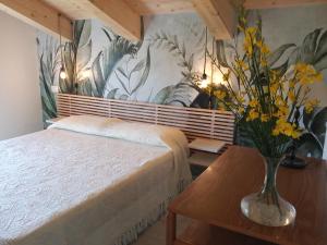 a bedroom with a bed and a vase of flowers on a table at Rifugio Belvedere in Onelli