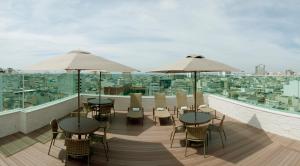 balcón con mesas, sillas y sombrillas en Américas Copacabana Hotel, en Río de Janeiro