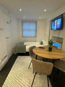 a room with a table and a bed and a bedroom at Beautiful Cosy Apartment in King's Cross in London