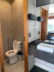 a bathroom with a toilet and a sink at Espaço horizonte verde in Ribeirão Preto