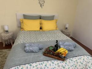 Una cama con una bandeja de plátanos. en Casa Mary Bela's, en Quinta do Almeida