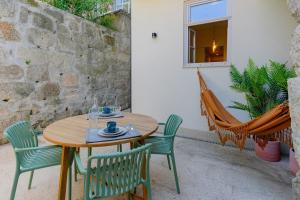 a wooden table and chairs on a patio at Spacious apartment with patio at historic center in Porto