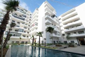 カサブランカにあるPremium Romantic 1 Bedroom & Living Room with Swimming pool & Garden viewのヤシの木が茂るアパートメントビル