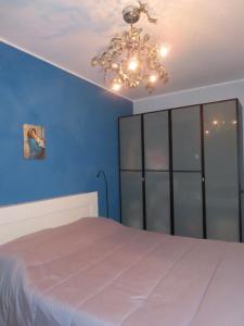 a bedroom with a large bed and a chandelier at Relax sul mare in Acireale