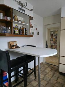 a kitchen with a white table and two black chairs at Steinlisonne in Möhlin +7 photos
