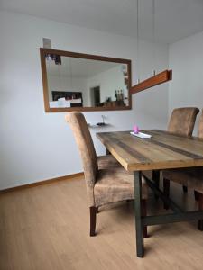 une table en bois avec deux chaises et un miroir dans l'établissement Steinlisonne, à Möhlin