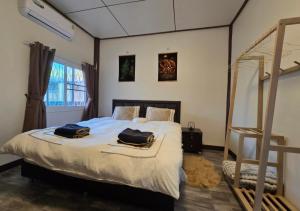 a bedroom with a bed with two bags on it at Hua Hin House in Hua Hin +19 photos