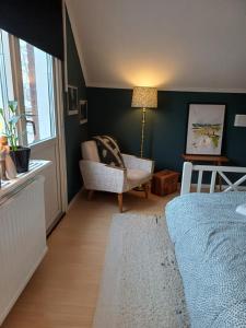 a bedroom with a bed and a chair and a window at Villa with hot tub and sauna in Umeå