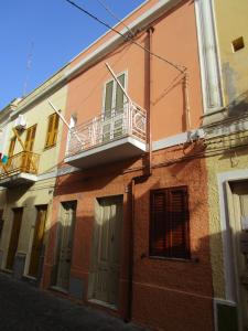 a building with a balcony on the side of it at Casa Danero "U dabassu" - Centro storico di Carloforte in Carloforte