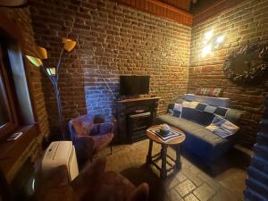 a living room with a couch and a brick wall at Cottage Plavi Lav Potok in Potok