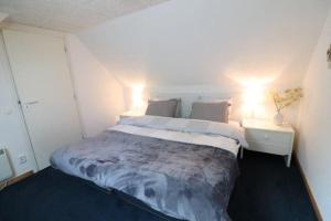 a bedroom with a large bed with two lights on it at Trésors de Lilain in Cheylade