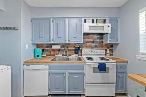una cucina con mobili blu e un lavandino di 2BR Retreat with Pool, Near Beach and The Hangout a Gulf Shores