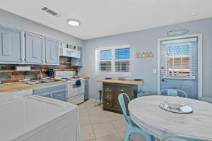 una cucina con pareti blu e tavolo con sedie di 2BR Retreat with Pool, Near Beach and The Hangout a Gulf Shores