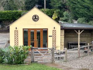 a small yellow building with a wooden door at Mini haven in Oswestry