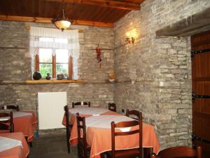 a dining room with tables and a stone wall at Hotel Kalemi in Gjirokastër