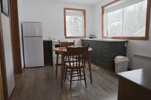 a kitchen with a table and chairs and a refrigerator at loft Gem in Duhamel