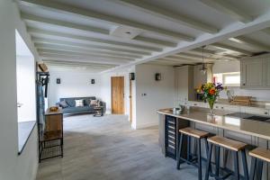 an open kitchen and living room with a couch at Tractor Shed, seaside cosy cottage for 4 in Beaumaris
