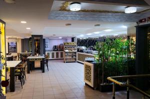 a restaurant with tables and chairs and plants at Hotel Yılmazel in Gaziantep