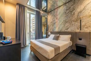 a bedroom with a bed and a stone wall at Amari120Suite&Spa in Palermo