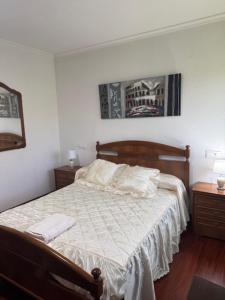 Un dormitorio con una cama con dos mesitas de noche y dos mesas. en Pensión Portus Marini, en Portomarín