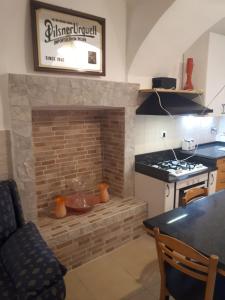 a kitchen with a brick fireplace with a stove at borgo romantico in Villar Dora