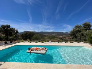 a man laying on a raft in a swimming pool at Cigarral Bramasole in Los Navalucillos