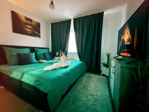 a bedroom with a green bed with a doll on it at Zara’s Home Apartaments in Petroşani