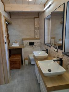a bathroom with two sinks and a mirror at Domek U Babci in Istebna