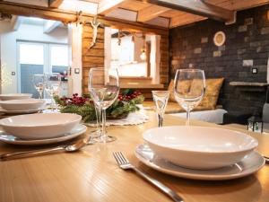 a wooden table with plates and wine glasses on it at Domek U Babci in Istebna