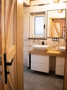 a bathroom with two sinks and a mirror at Domek U Babci in Istebna +8 photos