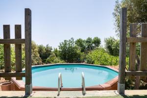 a swimming pool behind a wooden fence at Sweet House in Islas Baleares