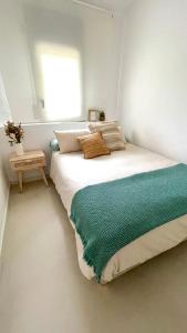 ein Schlafzimmer mit einem Bett mit einer grünen Decke darauf in der Unterkunft Sa Tina - Casa con encanto en la Costa Brava L'Estartit in Torroella de Montgrí + 15 Fotos