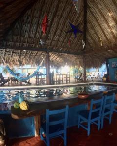un bar dans un complexe avec des chaises et une piscine dans l'établissement Rancho de Chana Perla Salina, à Flandes