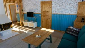 een woonkamer met een bank en een open haard bij Sunshine Stuga Mörtsjön in Stugun