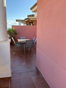 a patio with a table and chairs on a balcony at El Ático de Brisaquebrada - Vista Mar - Gran Terraza in Benalmádena