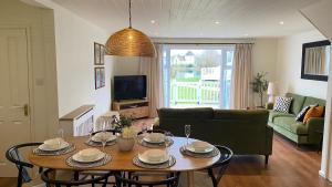 a living room with a table and a couch at Pegasus Lodge in the Cotswolds in South Cerney +20 photos