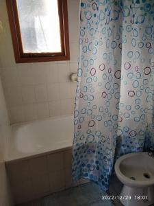 a bathroom with a shower curtain and a sink at La casa de Gaby in San Martín de los Andes