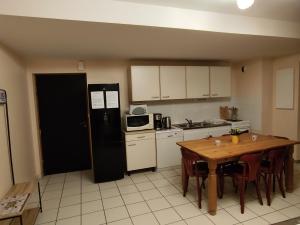 a kitchen with a table and a black refrigerator at Auberge du Roc Saint Jean in Ayssènes-la-Bacaresse