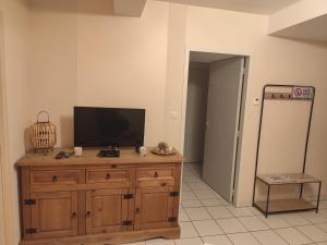 a room with a television on a wooden dresser at Auberge du Roc Saint Jean in Ayssènes-la-Bacaresse