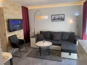 a living room with a couch and a table at Květinové apartmány Horní Planá in Horní Planá