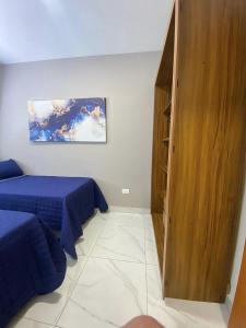 a bedroom with two beds and a wooden cabinet at FL04 - Decoração Moderna a 500m da Expo Center Norte in Sao Paulo