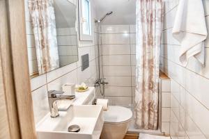 a white bathroom with a sink and a toilet at Shell & Pebble in Acharavi +19 photos