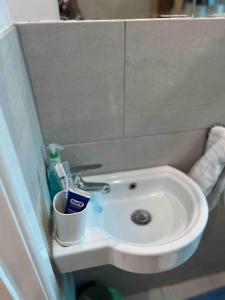 a bathroom sink with a toothbrush and a cup on it at Studio flat with private entrance in Lewisham +16 photos