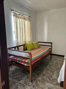 a bed with yellow pillows on it in a room at La Mar Paraty Hospedaria 05 in Paraty
