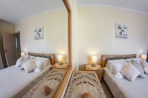 a bedroom with two beds and a large mirror at Shell & Pebble in Acharavi