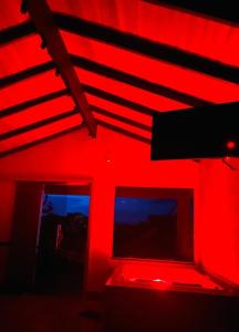 a red room with two windows and a red light at Chalé Verde Bonança in Pirenópolis